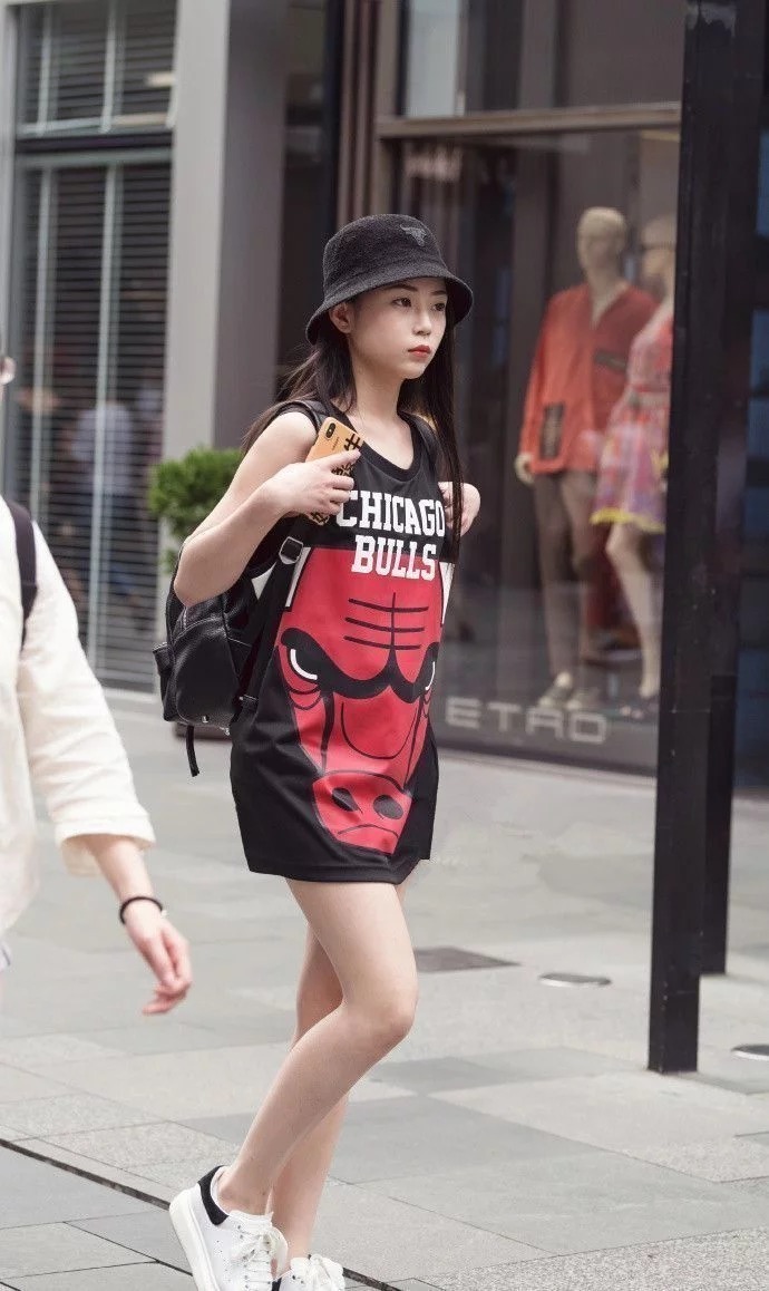 街拍:小姐姐身穿红色无袖上衣,白色的长裤,造型很时尚