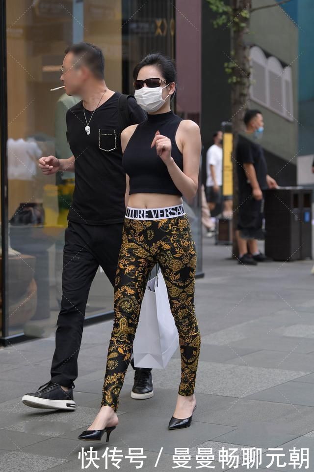 阿姨黑色半高领上衣搭配花纹修身裤,设计精美,尽显时髦气息