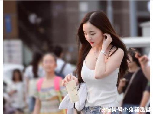  长裙|街拍美女搭配一袭粉色长裙，显色十分典雅，衬托出大长腿很迷人