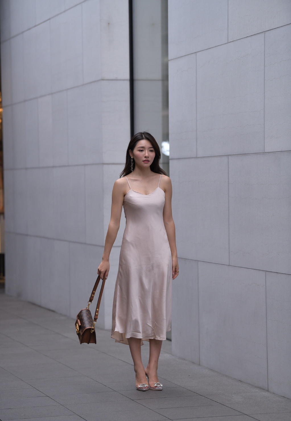 美女街拍:近肤色吊带裙真亮眼,搭配“透明酒杯鞋”,乍一看以为是“贵妇”