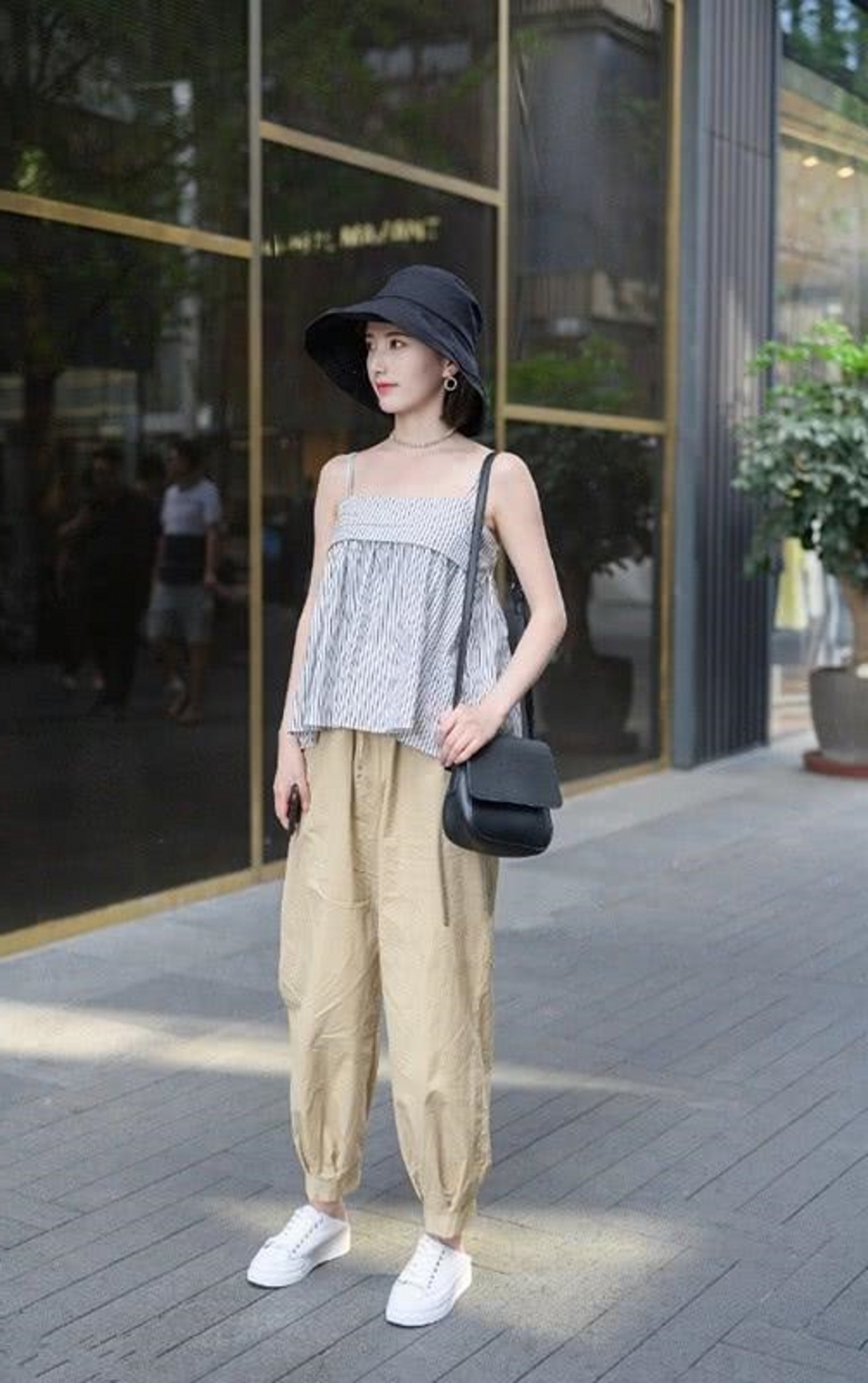 路人街拍,黑色的休闲裤搭配一件小背心,气质时髦感十足