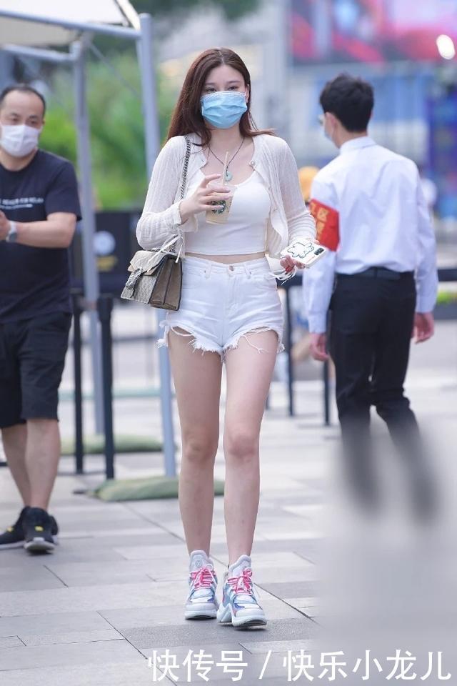 美女短款紧身吊带短袖,搭配碎边设计白色热裤,彰显时尚与魅力