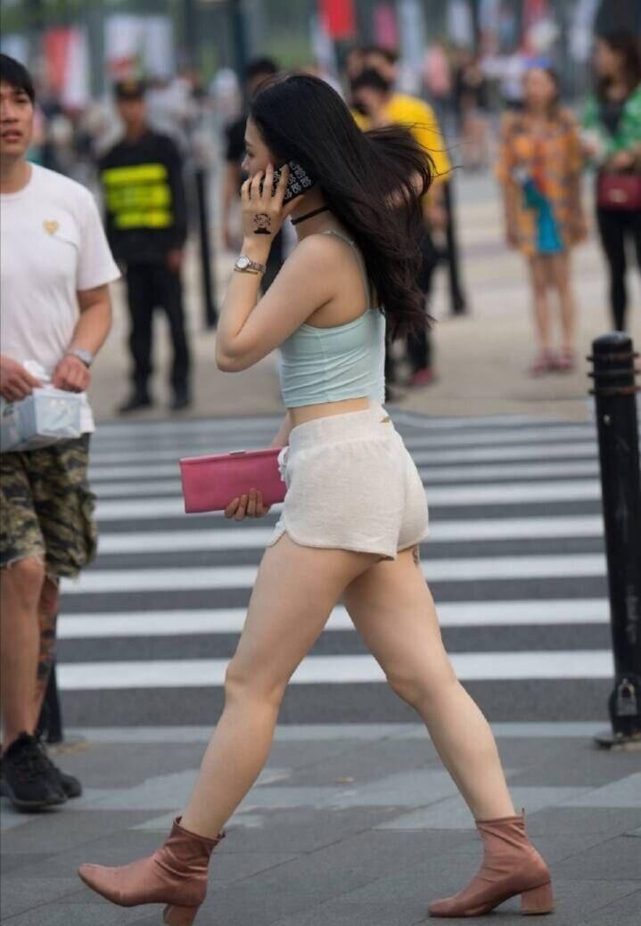 路人街拍,小姐姐穿着水绿色的吊带短衫,活力十足非常时尚