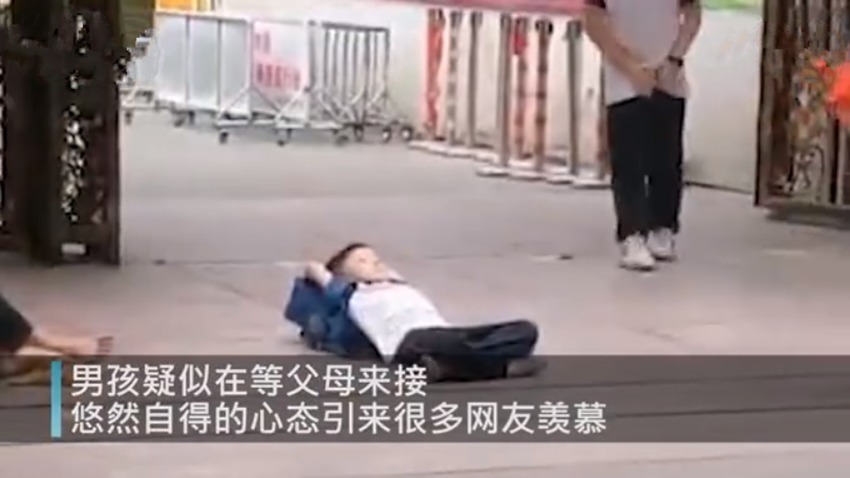 校门口|小男孩躺校门口等人接,“佛系”态度引网友羡慕这娃以后不简单