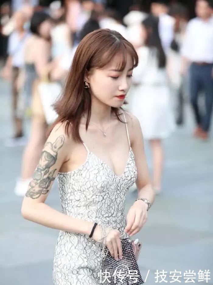 街拍:小姐姐身穿一条白色印花吊带裙,性感中带着一丝文艺小清新