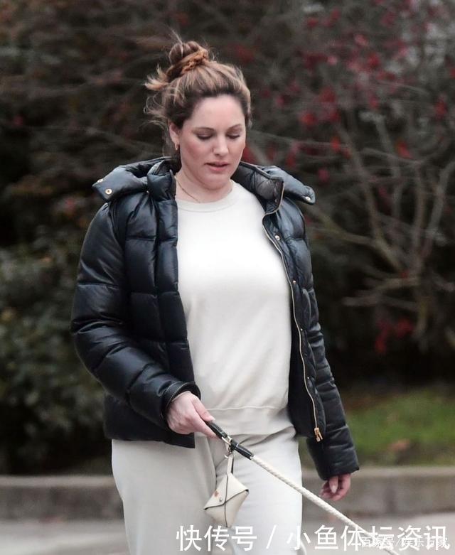 凯莉·布鲁克穿白色套装和黑色羽绒服外出遛狗很惬意