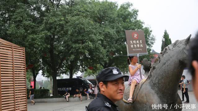 游客攀爬景区雕塑拍照，保安喊话无效后，竟默默地递上了一块牌子