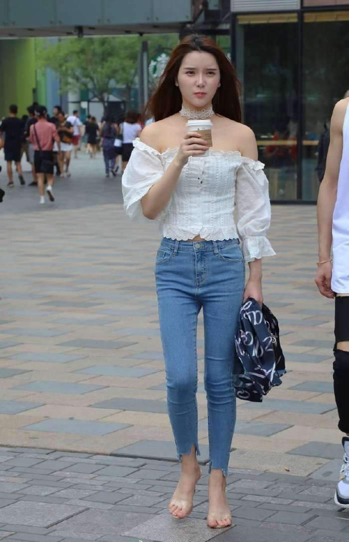 展现|街拍:美女穿着白色的抹胸上衣搭配牛仔裤,美腿曲线完美的展现!