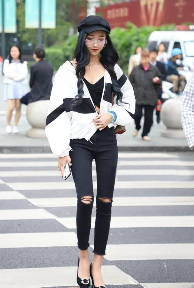 路人街拍，姑娘身穿黑色的短裤，露出修长的双腿很是俏皮