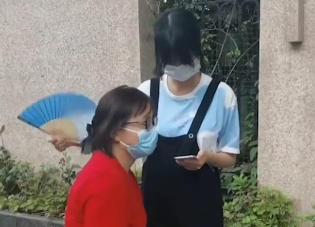 考场|高考生在考场外边看手机复习边给妈妈扇扇子，网友大赞：心态满分