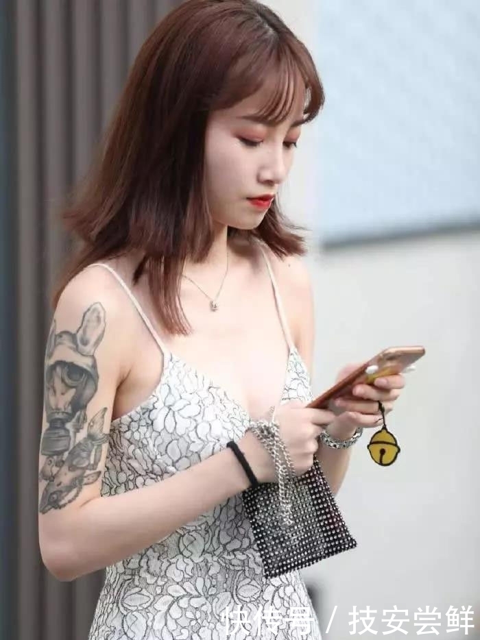 街拍:小姐姐身穿一条白色印花吊带裙,性感中带着一丝文艺小清新