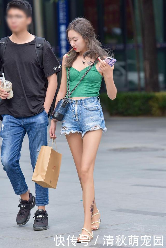 墨蓝针织吊带衫,搭配水洗破洞牛仔短裤,尽显时尚活力