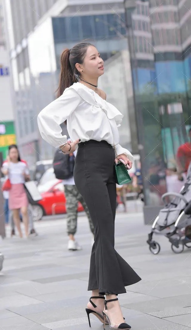 喇叭裤 皮肤白皙的美女,一件白色露肩上衣搭配黑色喇叭裤穿搭出众显贵气