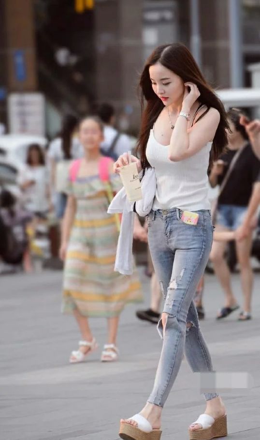 街拍:小姐姐身穿紧身超短上衣搭配牛仔裤,秀出性感细腰长腿!