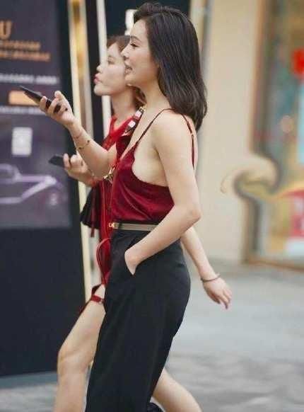 街拍小姐姐身穿红色吊带背心性感娇艳,搭配休闲裤帅气又随性