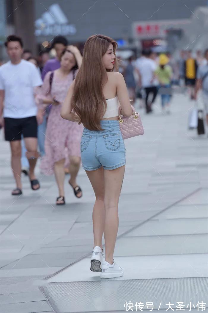 黄金比例|美女街拍:白色挂脖式针织上衣,搭配牛仔短裤和小白鞋,时尚性感又减龄好看