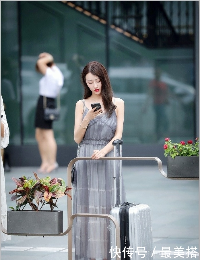 起舞|街拍:小姐姐身穿一件黑色吊带连衣裙,裙摆随风起舞