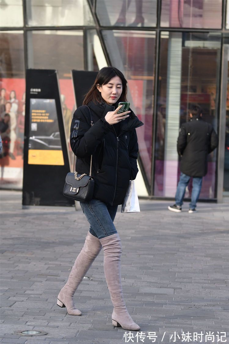 街拍 街拍:美女搭配黑色羽绒服,选择牛仔裤和过膝靴,别样的时尚味道