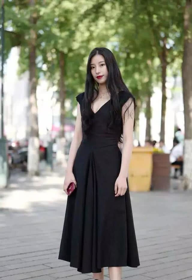 黑色|路人街拍,美女穿着一件黑色的刺绣印花大衣,休闲感十足