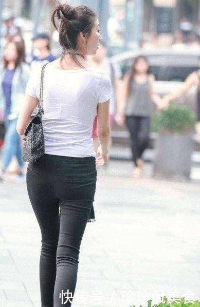 牛仔裤|街拍美女黑色短款皮夹克,搭配高腰的黑色牛仔裤,时尚有个性