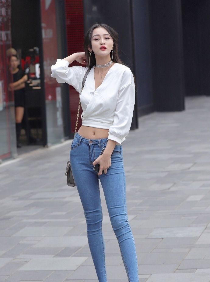 街拍|街拍：蓝色牛仔搭配白色上衣，天鹅颈小姐姐自信美丽