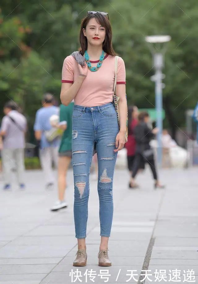 粉红色|小姐姐身穿粉红色短款上衣搭配破洞牛仔裤，洋溢着青春靓丽的风姿