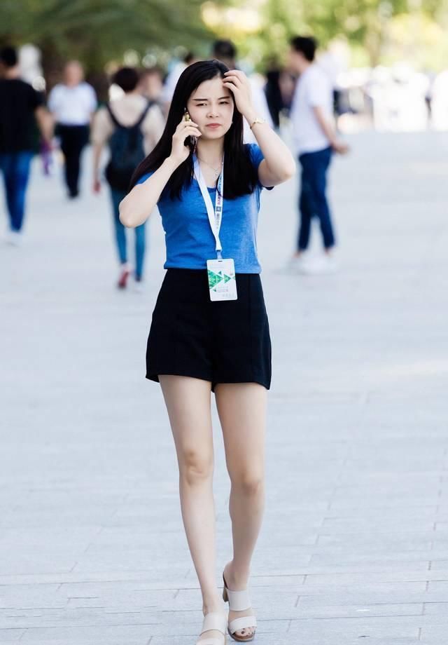 短袖|街拍黑色休闲短裤搭配蓝色短袖T恤,小姐姐打电话的姿势要优雅