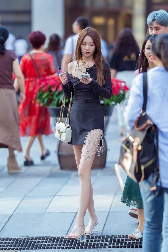 街拍小姐姐身穿靓丽连衣裙,脚踩高跟凉鞋,女神范十足