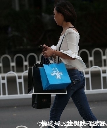 街拍|街拍:紧身牛仔裤搭配白色露肩装的美女,甜美笑容让人印象深刻
