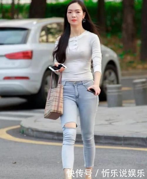 街拍小姐姐浅蓝色牛仔裤搭配白色休闲衫，全面提升气质与魅力