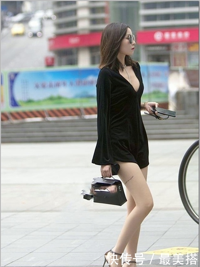 起舞|街拍:小姐姐身穿一件黑色吊带连衣裙,裙摆随风起舞