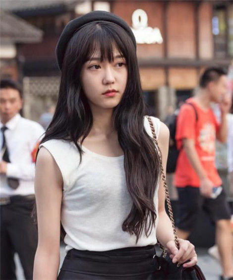 街拍:美女粉色上衣搭配白色短裙,身材妩媚多姿,很显气质