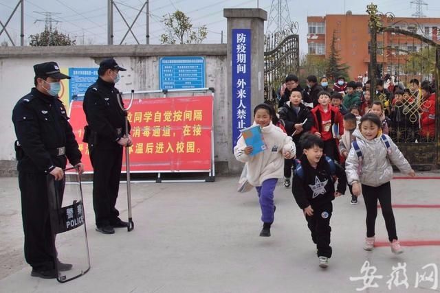 淮南市中小学校24日开学，民警为学生撑起“平安伞”