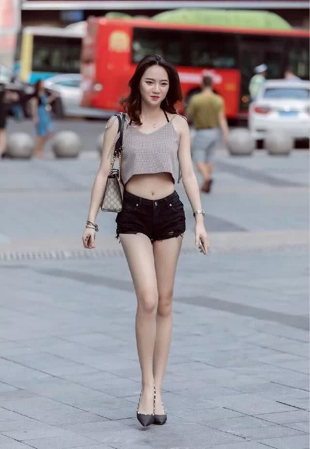 街拍小姐姐身穿吊带,脚踩尖头的黑色高跟鞋,十分帅气