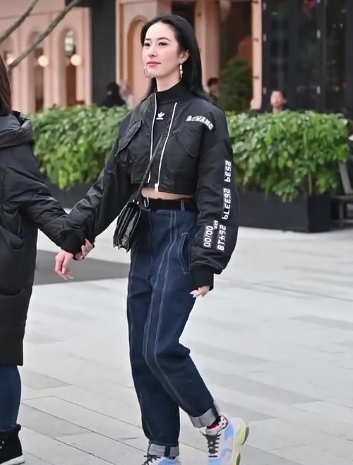 街拍美女黑衣蓝裤的小姐姐好帅气，抬脚就被“猫印鞋”抢镜了