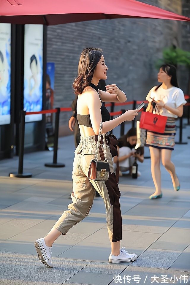 棕色|美女街拍:黑色挂脖上衣搭配拼色工装裤,搭配布条腰带,时髦个性干净利落