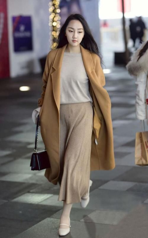 她款款走来，大衣和阔腿裤搭配在一起，简约舒适尽显洒脱气质