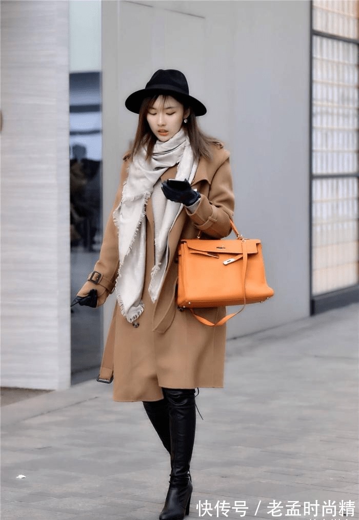 身材高挑 棕色呢子大衣,搭配黑色过膝皮靴,粗跟款式,衬托身材