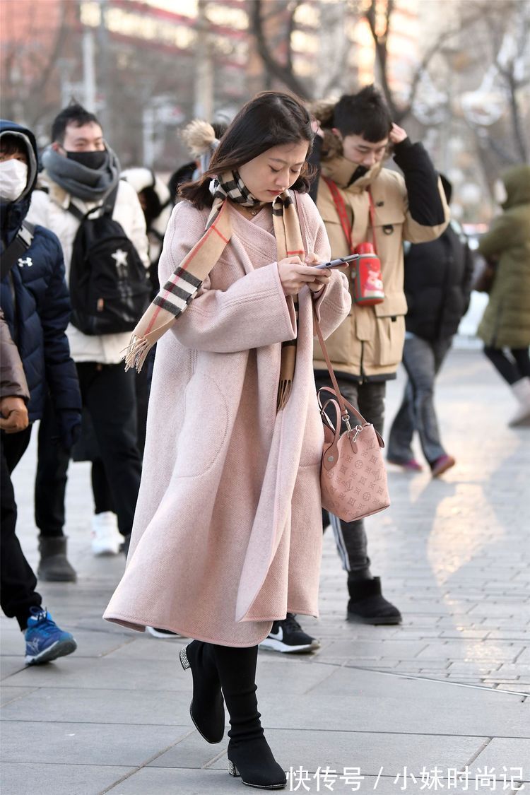 毛呢连衣裙|街拍:美女搭配粉红色的毛呢连衣裙,黑色高跟过膝靴,非常时尚!
