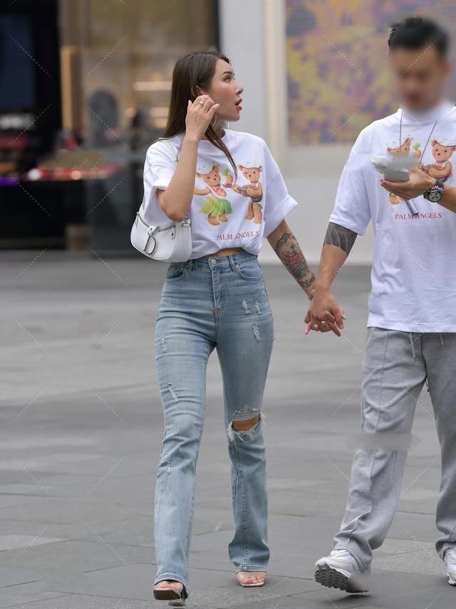 破洞喇叭裤配上可爱的印花白T，个性十足的休闲风范