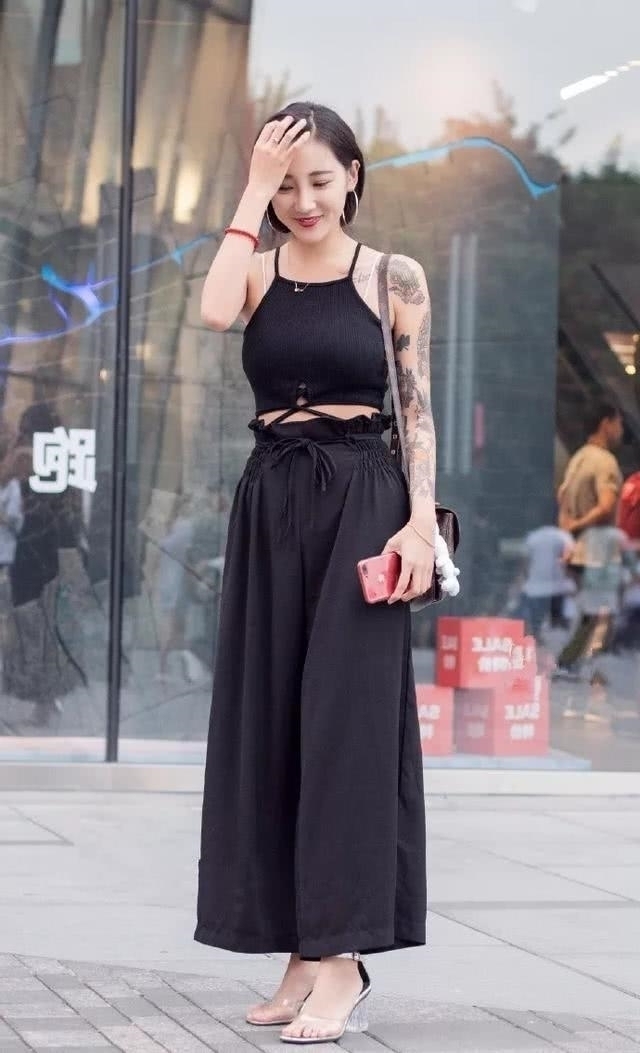 路人街拍，小姐姐穿着一件短款的吊带背心，显得更加的迷人