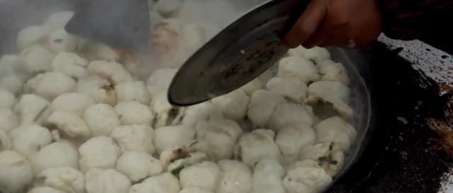 一位65岁老汉在大集卖小吃,露天柴火烧,顾客大老远跑来吃