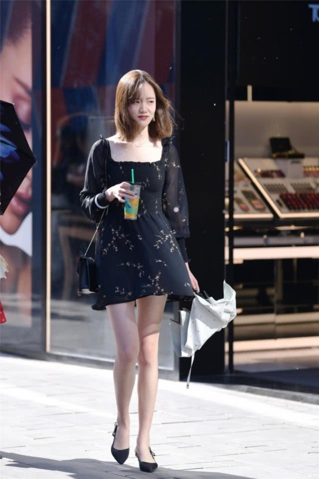 街拍：美女边走边喝饮料的，黑色连衣裙素雅大方