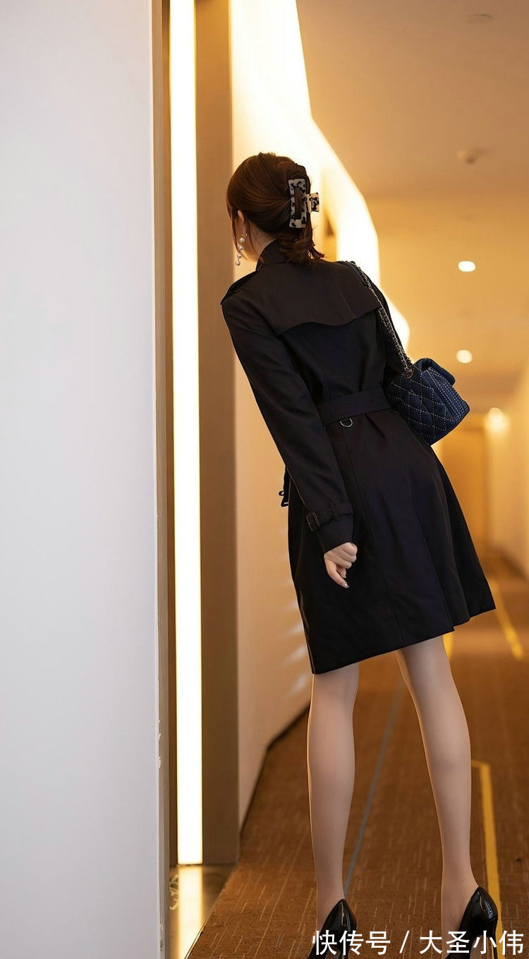 街拍|美女街拍:黑色的风衣是很经典的款式,穿起来会很显瘦,搭配高跟鞋更加漂亮