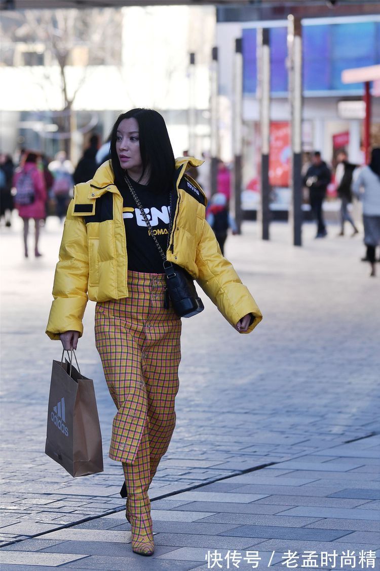 羽绒服 街拍:小姐姐蓝紫色的羽绒服,搭配黑色裙子和打底裤,时尚靓丽!