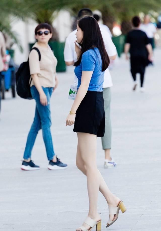 短袖|街拍黑色休闲短裤搭配蓝色短袖T恤,小姐姐打电话的姿势要优雅