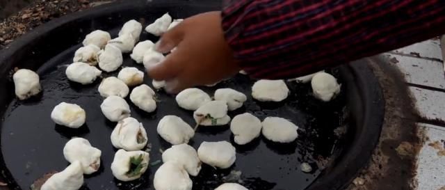 一位65岁老汉在大集卖小吃,露天柴火烧,顾客大老远跑来吃