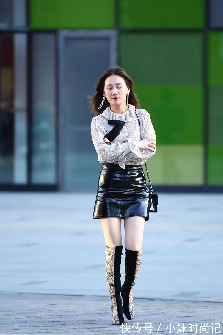美女 街拍:美女高腰的黑色漆皮短裙,搭配拼接色的过膝靴,非常洋气!