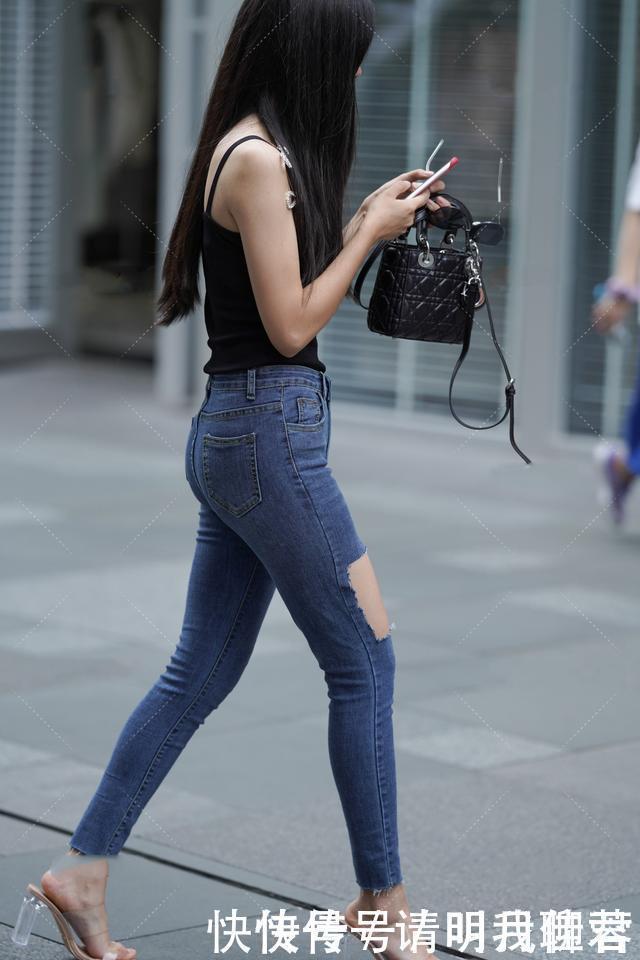 黑色吊带背心+紧身牛仔裤，简约时尚，让小姐姐秀出不一样的魅力