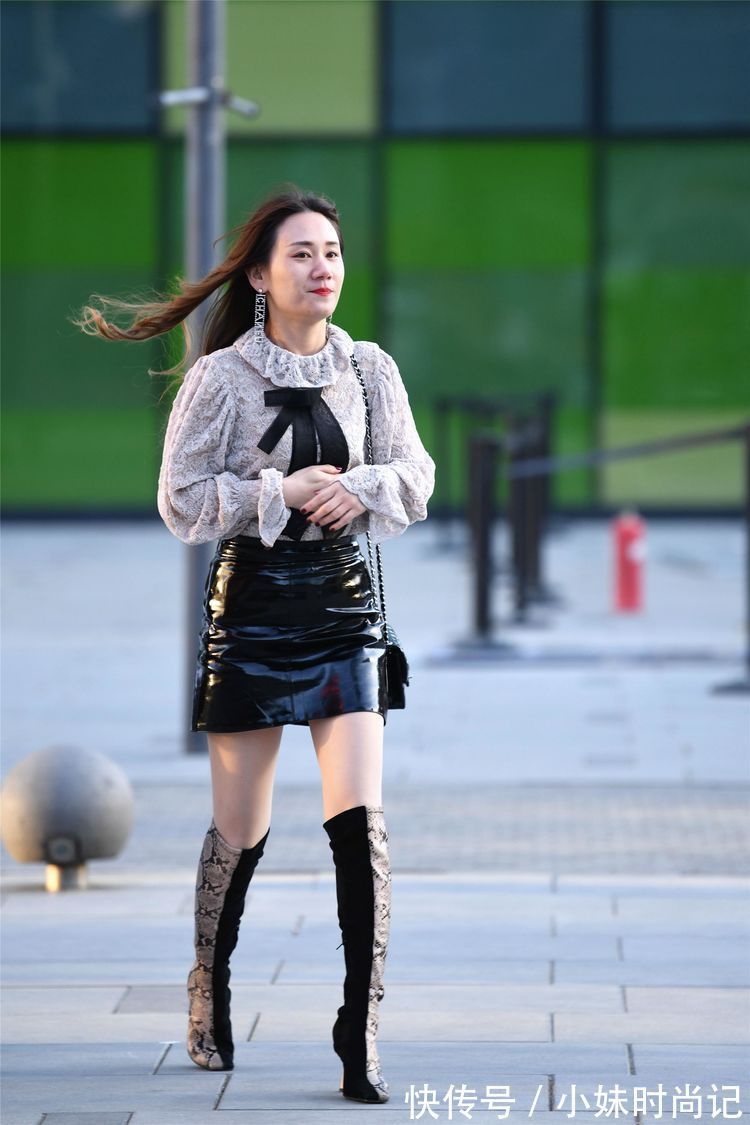 美女 街拍:美女高腰的黑色漆皮短裙,搭配拼接色的过膝靴,非常洋气!